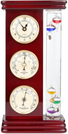 three clocks in a glass case on top of a wooden stand with an hour and minute marker