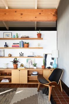 a living room with shelves filled with books and plants