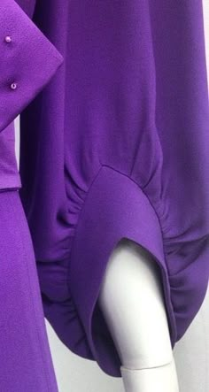 a purple dress with buttons on the collar and sleeves is displayed in front of a mannequin's head