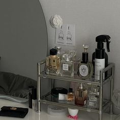 a mirrored shelf with bottles and cosmetics on it