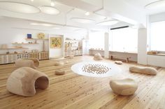 a large room with wooden floors and white walls, filled with various objects on the floor