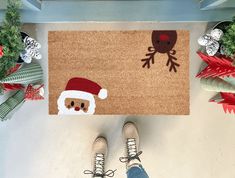 Handmade coir doormat with a Santa face and reindeer design. Made in the USA, available in three sizes, perfect for adding holiday cheer to your entryway. Christmas Mat Painting Ideas, Diy Christmas Floor Mat, Painted Door Mat Christmas, Christmas Outdoor Rug, Christmas Coir Doormat, Coir Doormat Diy Christmas, Diy Painted Doormat Christmas, Western Door Mats, Diy Christmas Rug