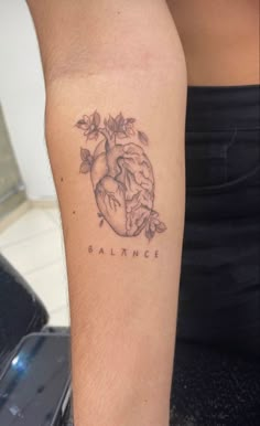 a person with a tattoo on their arm that has the word balance written in it