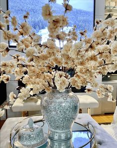 a vase with flowers in it sitting on a table next to a glass plate and bowl