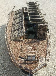 a boat that is sitting on the ground next to another boat in the gravel and some metal bars attached to it