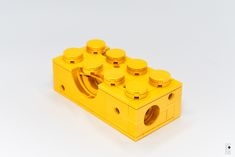 a yellow lego block is shown on a white surface