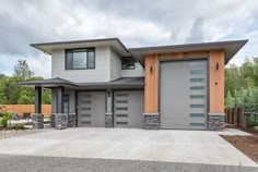 a modern house with two garages in the front and one on the back side