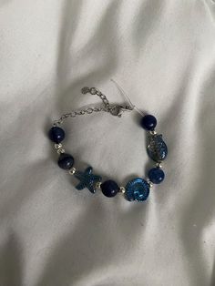 This is a beach / sea inspired handmade beaded bracelet. Blue beads with silver beads, silver charms and a silver clasp held together with a durable and stretchy elastic string. Perfect for summer and beach girl aesthetics <3 For Bracelet Size Chose Personalisation and Chose one of These Sizes Below :) Small - 13cm to 14.5cm Medium - 15cm to 16.5cm Large - 17cm to 18.5cm Extra Large - 18.5cm+ (specify) Ocean Bracelet, Girl Bracelet, Girl Aesthetics, Bracelet In Silver, Beach Bracelets, Sea Inspired, Bracelet Blue, Bracelets Handmade Beaded, Blue Bracelet