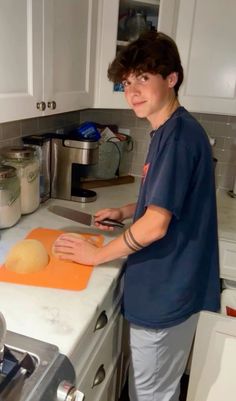 a person standing in a kitchen cutting food