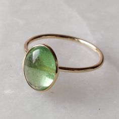 ITEM DESCRIPTION: >> The Ring is made from Solid 14K Yellow Gold. Gemstone used is absolutely natural and ethically sourced. >> Natural deep green emerald coloured garnet popularly known as Tsavorite is studded on it with utmost precision. >> This is a minimalist design which makes it a hassle free and everyday jewelry. Gem: Tsavorite Gem size: 7x9 mm Gem weight: Gemstone option 1 : 3.90 carats Gemstone option 2 : 2.69 carats Gemstone option 3 : 3.10 carats Gemstone option 4 : 14k Gold Green Ring With Polished Finish, 14k Gold Green Cabochon Jewelry, Green Tsavorite Rings With Bezel Setting, Green Rings With Bezel Setting In 14k Gold, Gold Tourmaline Ring For May Birthstone, 14k Gold Oval Cabochon Emerald Ring Gift, Green Oval Cabochon Birthstone Jewelry, Green Oval 14k Gold Jewelry, Oval Green 14k Gold Jewelry