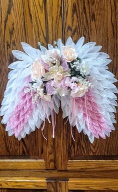 a bouquet of pink and white flowers sitting on top of a wooden door