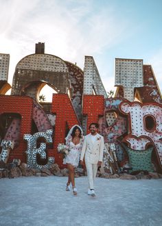 a newly married couple standing in front of the las vegas sign