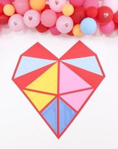 an origami heart surrounded by balloons