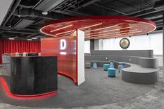 an empty office with red curtains and round desks