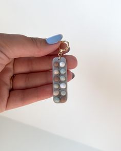 a hand holding a pill shaped key chain