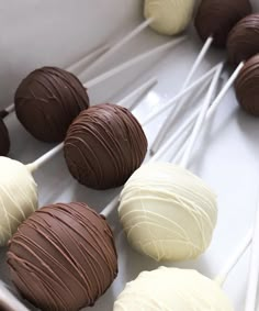 there are chocolates and marshmallows on the white plate with toothpicks