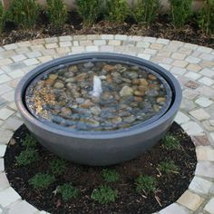 an outdoor fountain with rocks and water in it