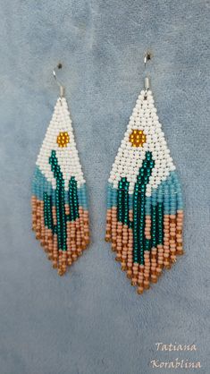 two pairs of beaded earrings on top of a blue surface with white and brown beads