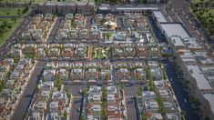 an aerial view of a city with lots of buildings and trees in the foreground