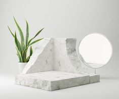 a white marble table with a mirror and plant