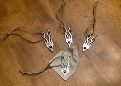 four pieces of silver metal with red eyes on them sitting on a wooden floor next to a cloth bag