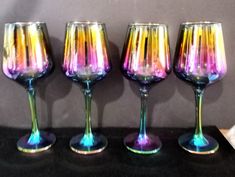 four colorful wine glasses sitting on top of a table