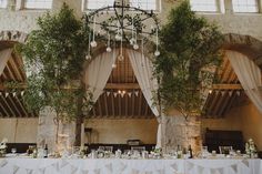 the tables are set up with white linens and greenery for an elegant wedding reception