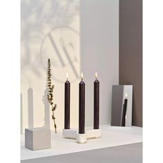 three candles sitting on top of a white table