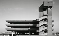 a tall building with many windows on top of it's sides in black and white