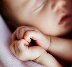 a close up of a baby's head and hands