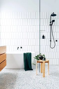 a bathroom with a tub, sink and shower head in the middle of the room