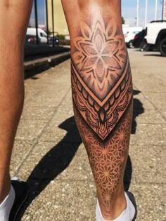 a man's leg with an intricate tattoo design on the calf and his legs