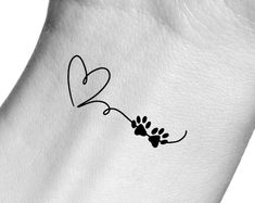 a dog paw with a heart tattoo on it's back side is shown in black ink