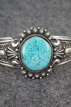 This stunning Kingman turquoise and sterling silver bracelet was made by Navajo silversmith Derrick Gordon. The back is signed Derrick and stamped Sterling.Size: 5 3/8" (will fit up to a 6 1/2" wrist)Gap: 1 1/8"Width: 1 1/2"Cuff Width: 1/2"Free shipping on all orders! We ship with USPS and always include tracking. All orders ship within a day of payment.Returns are accepted up to 30 days after you receive your order. Just send us a message. Our shop offers cash back or store credit. The item mus Handmade Turquoise Sterling Silver Western Bracelet, Western Style Blue Sterling Silver Collectible Bracelet, Western Style Blue Sterling Silver Bracelet Collectible, Western Turquoise Bracelet With Concho, Western Style Turquoise Bracelet With Concho, Western Turquoise Bracelets With Concho, Turquoise Western Style Collectible Bracelets, Kingman Turquoise, Sterling Silver Bracelet