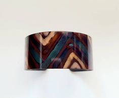 "This unique copper bracelet is made by painting patterns onto copper with a torch, and as the copper heats and cools it turns different colors naturally! Its quite an amazing process. The cuff is 1\" wide and is flexible enough so that you can make it fit your wrist. It is protected with a sealant to keep it from further oxidizing. These are custom made per order, so please keep in mind that with this process, nature is in charge of the colors, so see each one that I make is unique and cannot b Artistic Copper Cuff Bracelet, Artistic Copper Cuff Bracelet Bangle, Artistic Copper Cuff Bangle Bracelet, Handmade Brown Copper Bangle, Handmade Copper Bangle In Brown, Brown Copper Cuff Bracelet As Gift, Brown Copper Bracelet With Patina, Brown Copper Patina Bracelets, Brown Copper Bangle