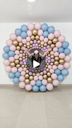 a woman standing in front of a giant balloon art piece with balloons surrounding her face