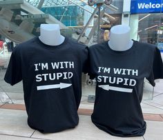 "I'm With Stupid Shirt / Matching Couple Shirts / Funny Sarcastic T Shirt / Short Sleeve Sarcasm Tee Gift / Couple Apparel  This cute and comical \"I'm With Stupid\" t-shirt set is the perfect choice for couples who want to showcase their playful dynamic in style. Featuring a classic unisex t-shirt design, both of the shirts reads \"I'm With Stupid\"  Crafted from comfortable and breathable cotton, these shirts are ideal for any activity, from running errands to a night out on the town. The shirts come in a variety of sizes, making it easy to find the perfect fit, and the stylish black color ensures that the shirts will always be in style.  Whether you're shopping for a fun couples gift for a special occasion, or you're simply looking for a way to add a little humor to your wardrobe, this Best Friend Shirts Funny Boys, Cute Matching Shirts For Couples, Matching Couple Shirts Funny, Funny Couples Shirts, Matching T Shirts Couple, Cute Couple Dynamics, Couples Shirts Funny, Matching Shirts Couple, Couple Shirts Funny