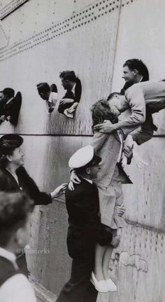 an old black and white photo of two people hugging each other on the side of a wall