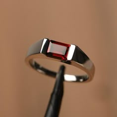 It is a garnet ring. The main stone is 6*8 mm emerald cut.weight about 1.92 carats.The basic metal is sterling silver and plated with rhodium.To change the metal to a solid gold (white/rose) or platinum is also available, please ask for a quotation if you want.You can also go to my shop Home for more elegant rings: https://www.etsy.com/shop/godjewelry?ref=hdr_shop_menu Garnet is the January birthstone.More garnet rings:https://www.etsy.com/shop/godjewelry?ref=seller-platform-mcnav&section_id=207 Chandi Rings Design For Men, Ruby Rings For Men, Ruby Ring Designs For Men, Silver Stone Rings For Men, January Birthstone Rings For Men, Garnet Ring Men, Garnet Rings For Men, Ruby Ring For Men, Platinum Rings For Men