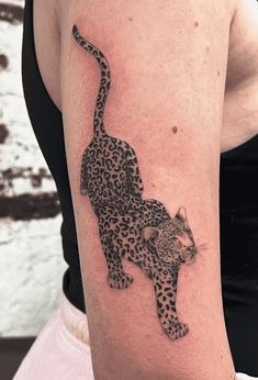 a woman's arm with a tattoo of a leopard on the left side of her body