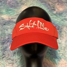 Get ready for a day at the beach with this stylish Salt Life visor hat. The red and white design is perfect for any fishing or beach-themed outfit. The adjustable strap ensures a comfortable fit for all sizes.

With its durable construction and classic style, this visor is a must-have accessory for any outdoor adventure. The Salt Life brand adds a touch of casual sophistication to your look, while the visor's adjustable feature ensures a perfect fit every time. Ideal for men who love the beach and want to look sharp, this visor is the perfect addition to any summer wardrobe. Visor Hat, Salt Life, Visor Hats, Themed Outfits, A Day At The Beach, Beach Themed, Day At The Beach, White Design, Beach Themes