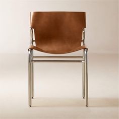 a brown leather chair sitting on top of a white floor next to a metal frame