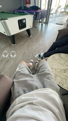 a person laying on the floor with their feet up in front of a pool table