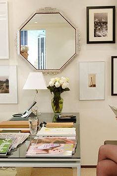 a desk with a mirror and flowers on it