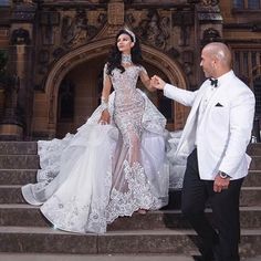 a man and woman in formal wear standing on steps