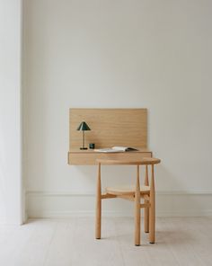 a wooden table with a lamp on top of it next to a wall mounted shelf