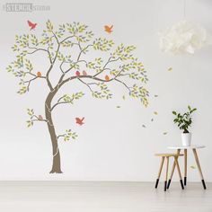 a tree with birds painted on it next to a white wall