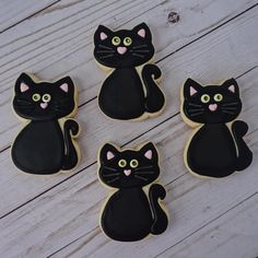 four decorated cookies with black cats on them