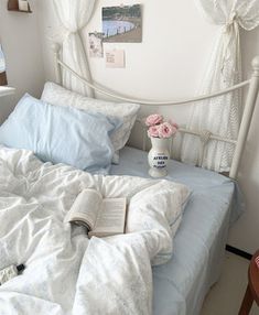 a white bed with blue sheets and pillows