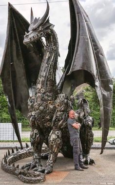 a man standing next to a statue of a dragon